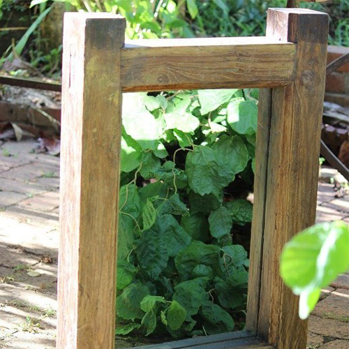 Aged timber garden mirror sitting on a walkway