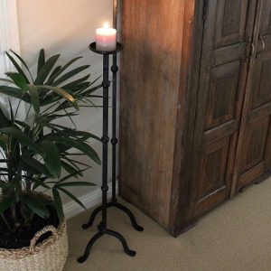 A candle stand with a lit candle on it