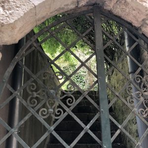 Trellis gate under stone arch in Sainte Agnes