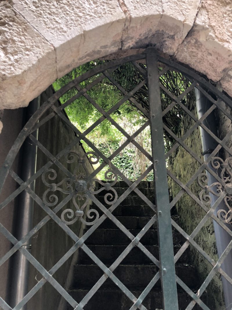 Trellis gate under stone arch in Sainte Agnes