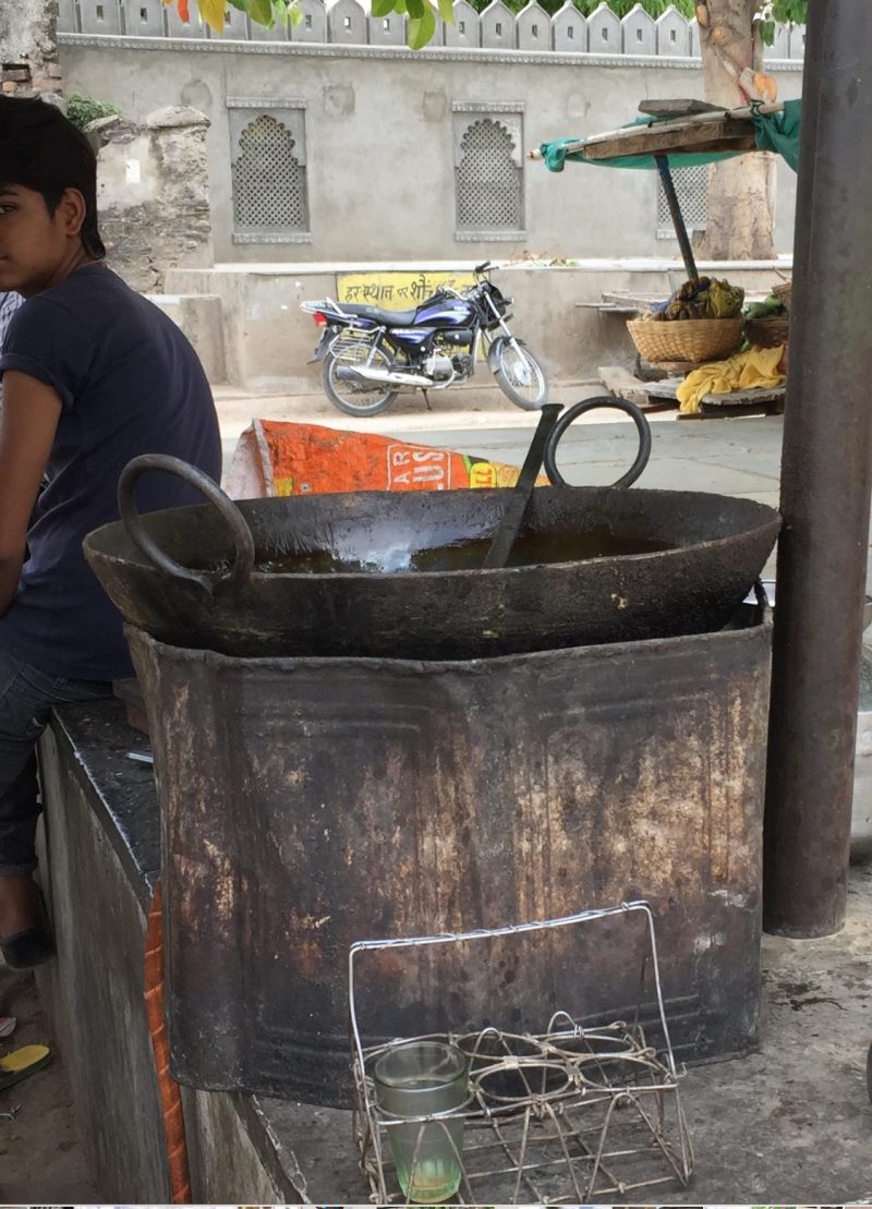 Boy with a cooking pot kadai in a street in India