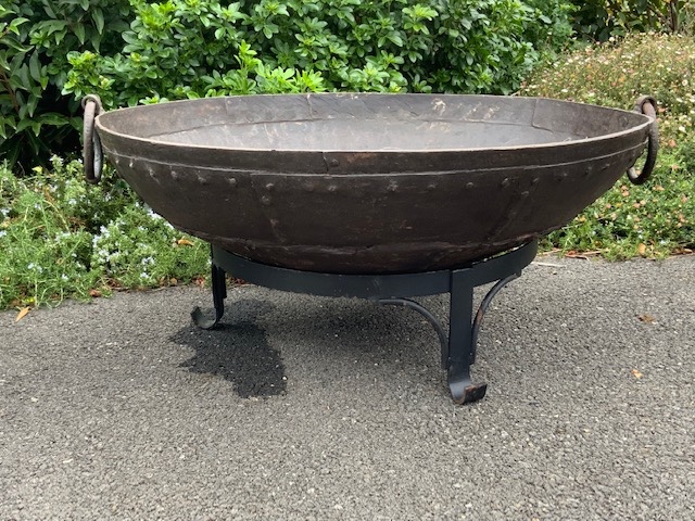 Fire pit with rivets in a garden