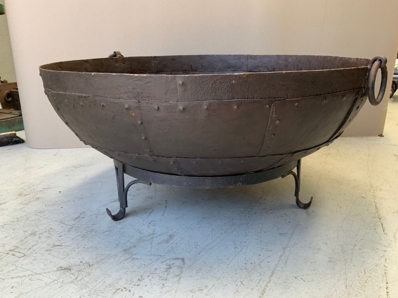 iron pot with rivets on a stand